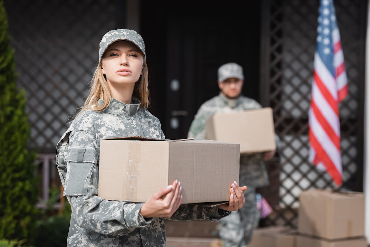 Fotografía de dos soldados estadounidenses cargando cajas de cartón