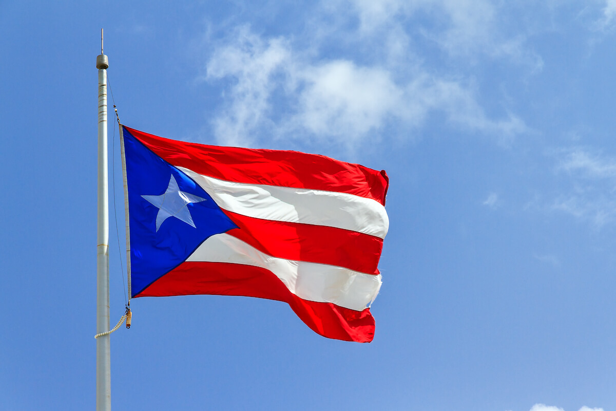 Bandera de Puerto Rico en el poste frente al cielo azul